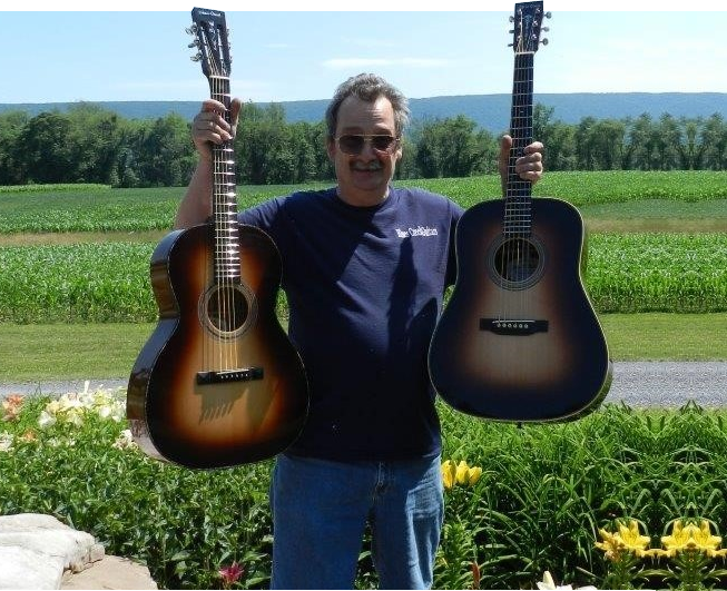 A man holding two guitars